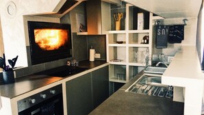 A modern kitchen with a built-in oven, a microwave, and a sink. - Gîte Lo Bornat: full of nature and sun, between sea and mountains (Puissalicon)