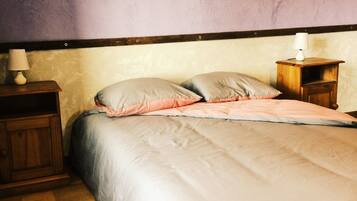 Una camera da letto con un letto, comodini in legno e una lampada.