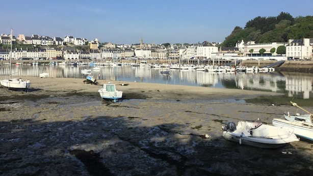 A harbor with boats docked, a sandy beach, and buildings in the background. - BRETONNE LONGERE BETWEEN SEA AND COUNTRYSIDE (Plouhinec)