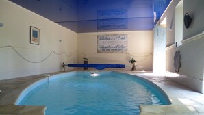 An indoor swimming pool with a tiled floor and a sign above reading "Chateau de la Voiture Bed and Breakfast". - Château de la Voûte, facing south (Troo)