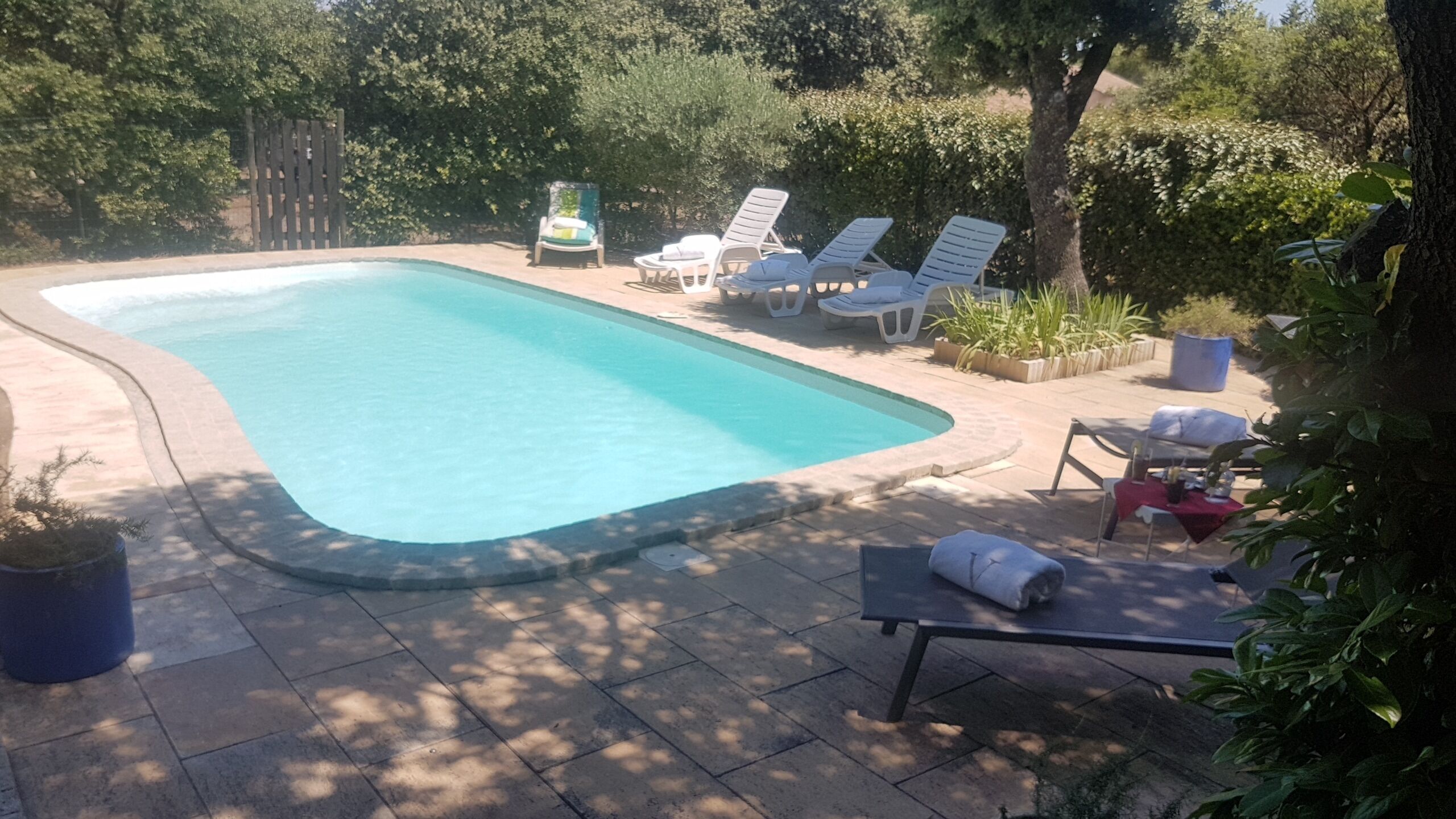 Una piscina con sillas de descanso y una pequeña mesa.