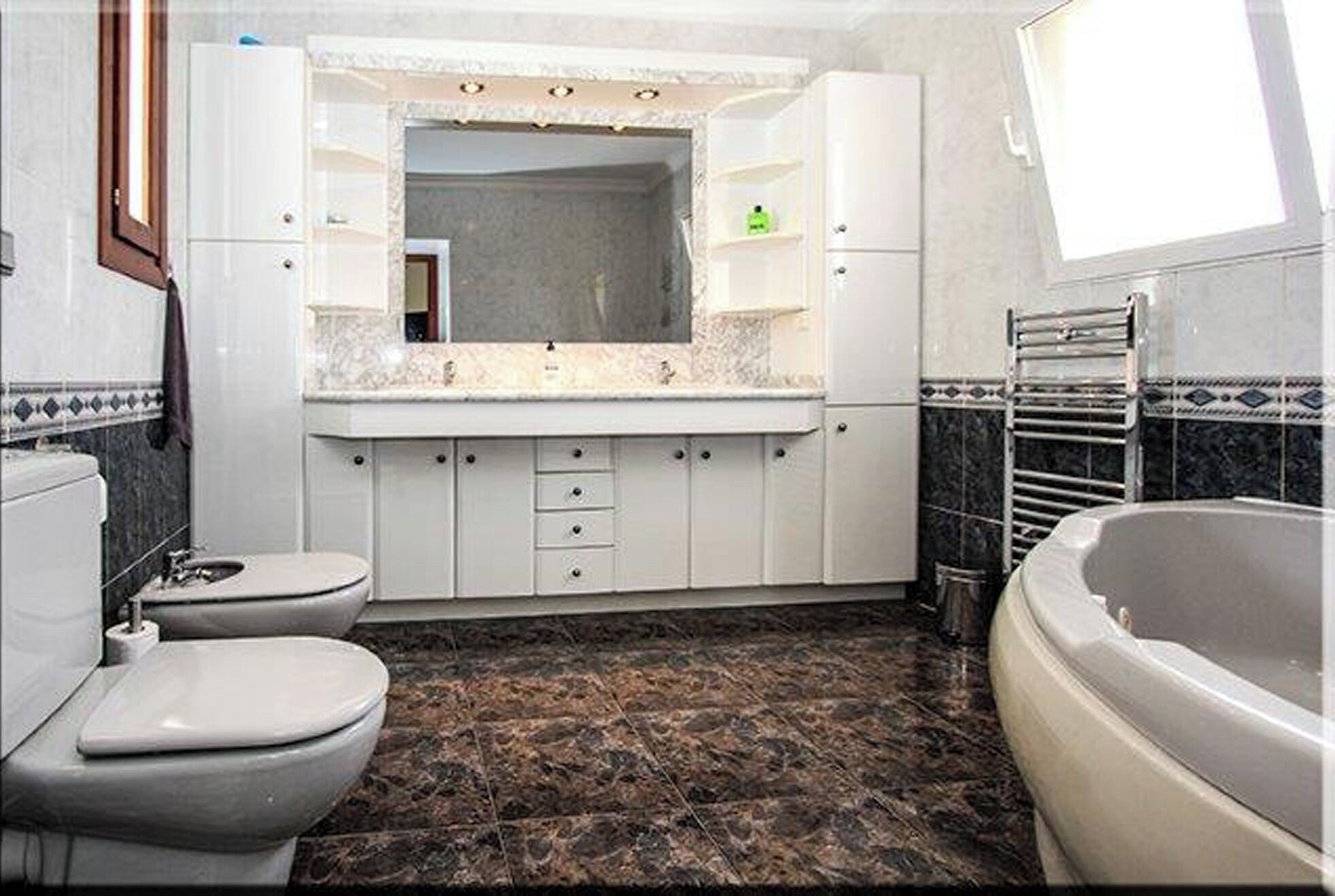 Een bad/douchecombinatie, een haardroger, een bidet, handdoeken