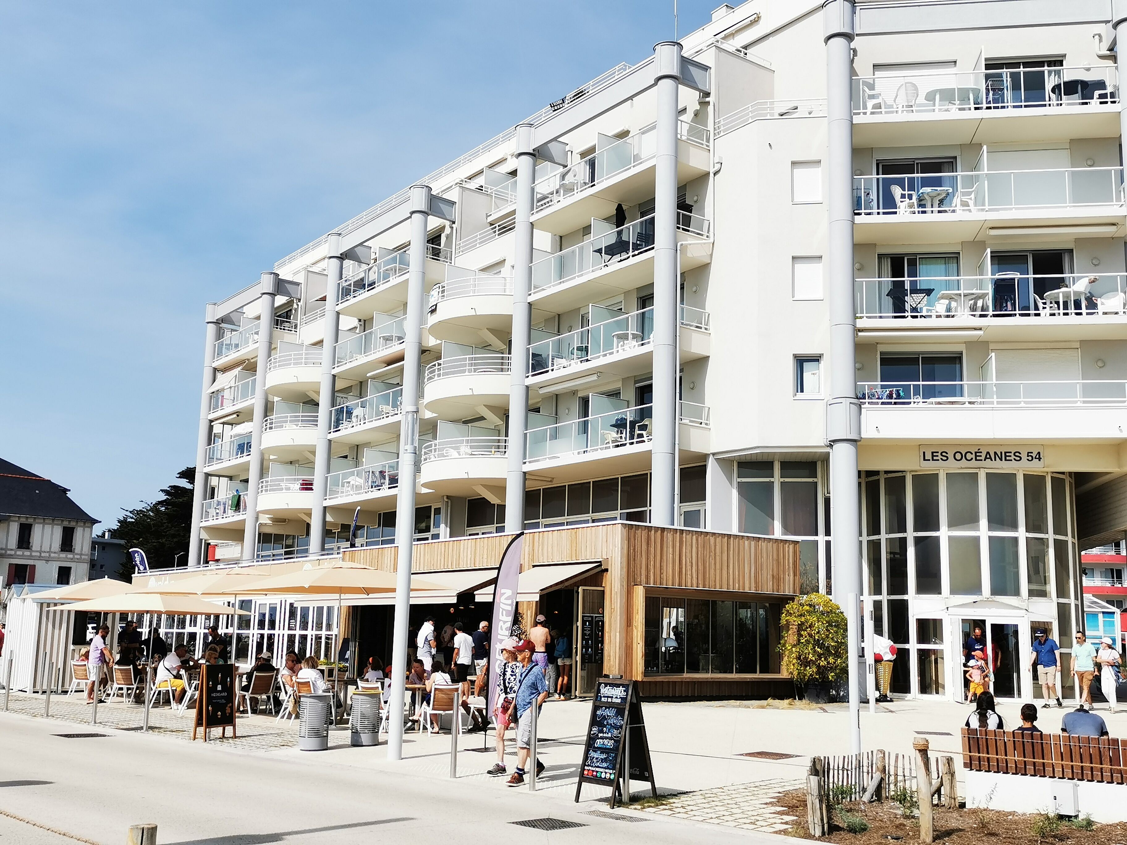 Un hôtel à plusieurs étages doté d’une terrasse et d’une enseigne indiquant « LES OCEANES 54 ».