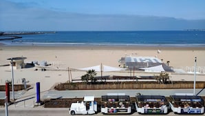 A beachside view with a white truck, a small building, and a row of beachside food trucks.