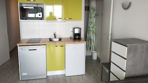 A compact kitchen with a microwave, sink, and coffee maker.