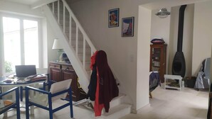 Una sala de estar con escalera, comedor y chimenea.