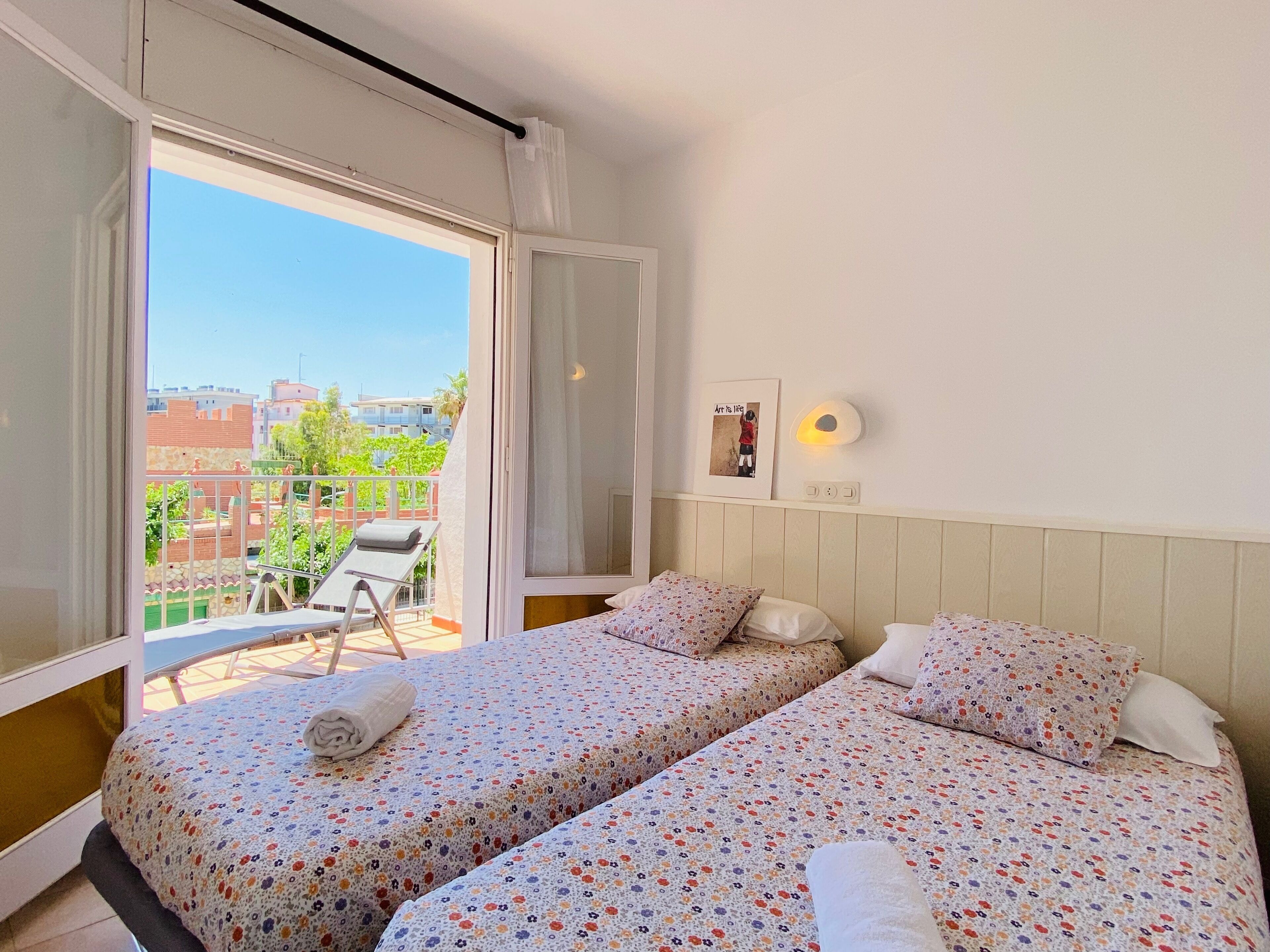 Una habitación con dos camas, un balcón y vistas a la ciudad.