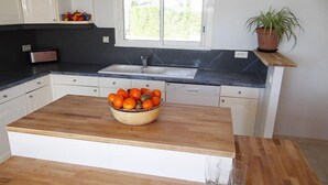 A kitchen with a wooden island, a sink, and a window. - GITE NEAR CAHORS WITH PRIVATE HEATED POOL (Le Montat)