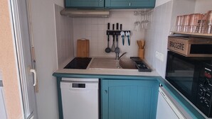 A compact kitchen with teal cabinetry, a dishwasher, a stove, and a Siemens oven. -  PRETTY STUDIO quiet, well located for the beaches of St Raphael and Frejus (Fréjus)