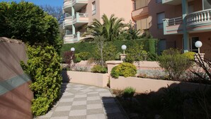 A residential building with multiple balconies, a paved pathway, and various plants. -  PRETTY STUDIO quiet, well located for the beaches of St Raphael and Frejus (Fréjus)