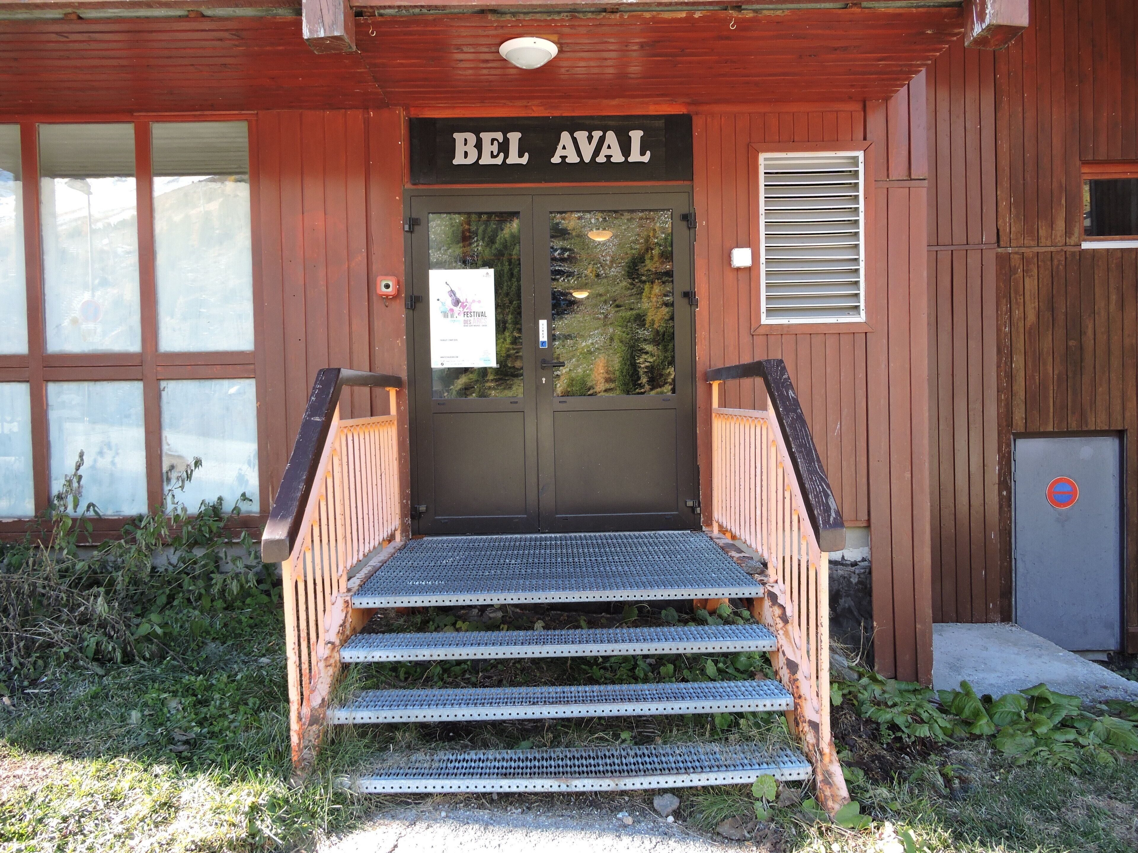 Un bâtiment en bois avec une enseigne indiquant « BEL AVAL » au-dessus de l’entrée.