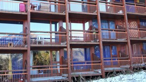 A multi-story wooden building with balconies, each featuring metal railings. - Studio Arc 2000, 4/5 persons, residence Bel Aval, Charlotte Perriand style. (Bourg-Saint-Maurice)