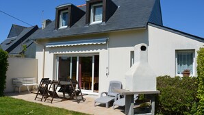 Una casa con un patio, un tavolo da pranzo e sedie.