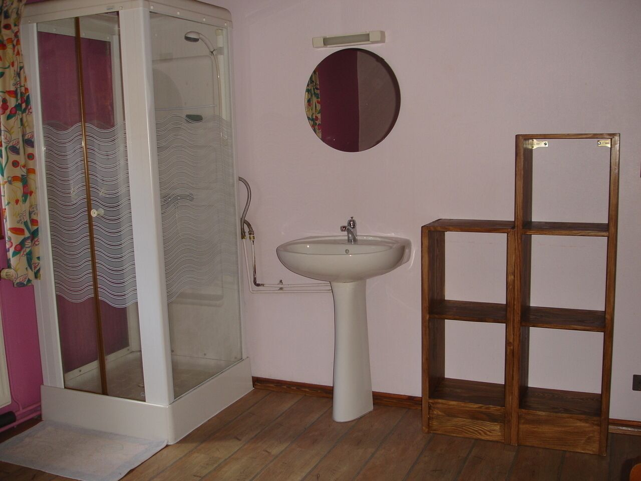 Une salle de bain avec une douche, un lavabo et un miroir.