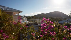 A house with a balcony overlooking a mountainous landscape. - Villa Colibri in Deshaies (Deshaies)