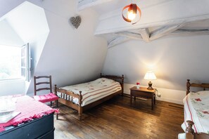 A bedroom with a wooden bed, a nightstand, a chair, and a window with a view.