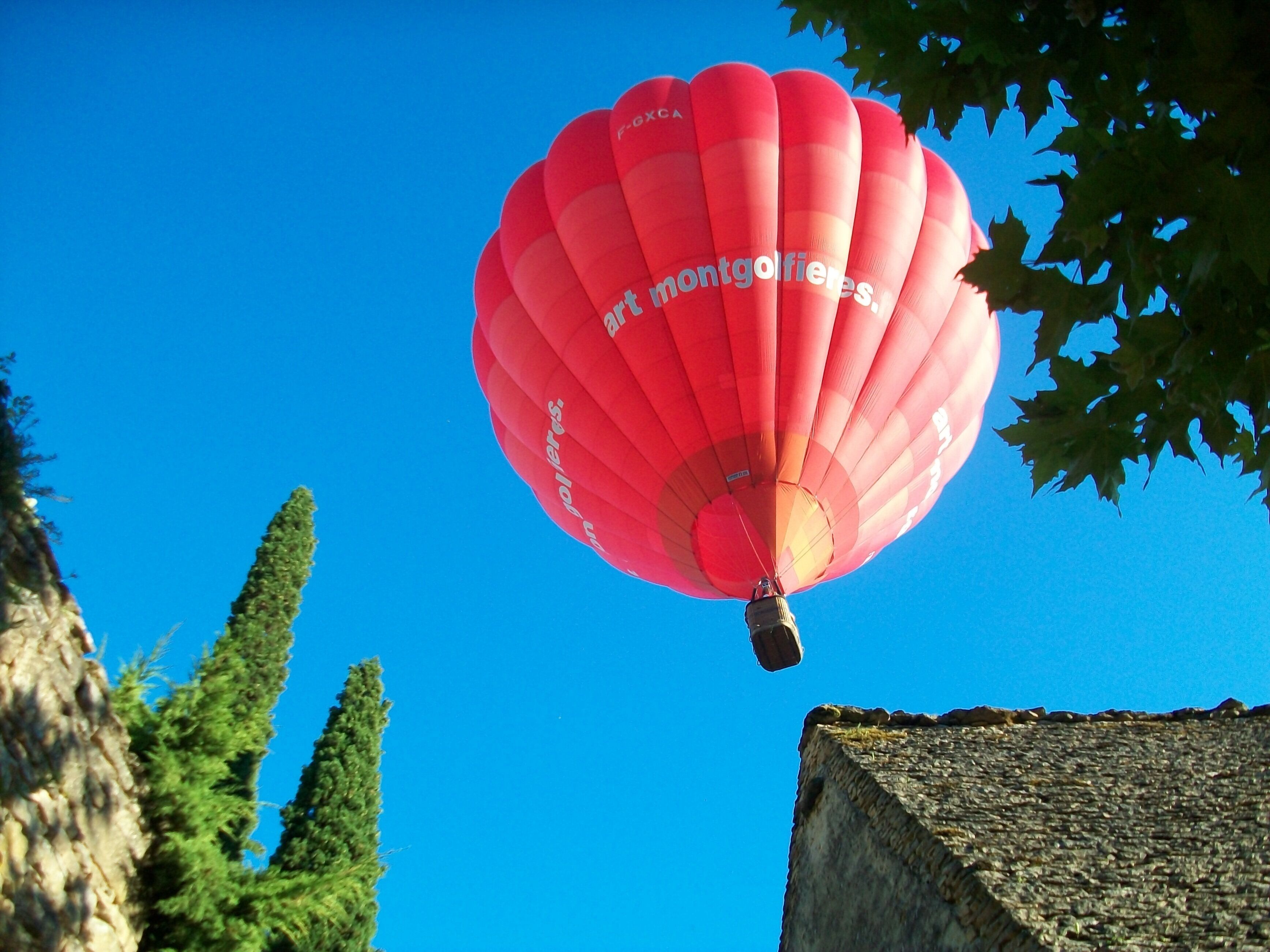 Une montgolfière avec l’inscription « montgolfières » se découpant sur un ciel bleu clair.