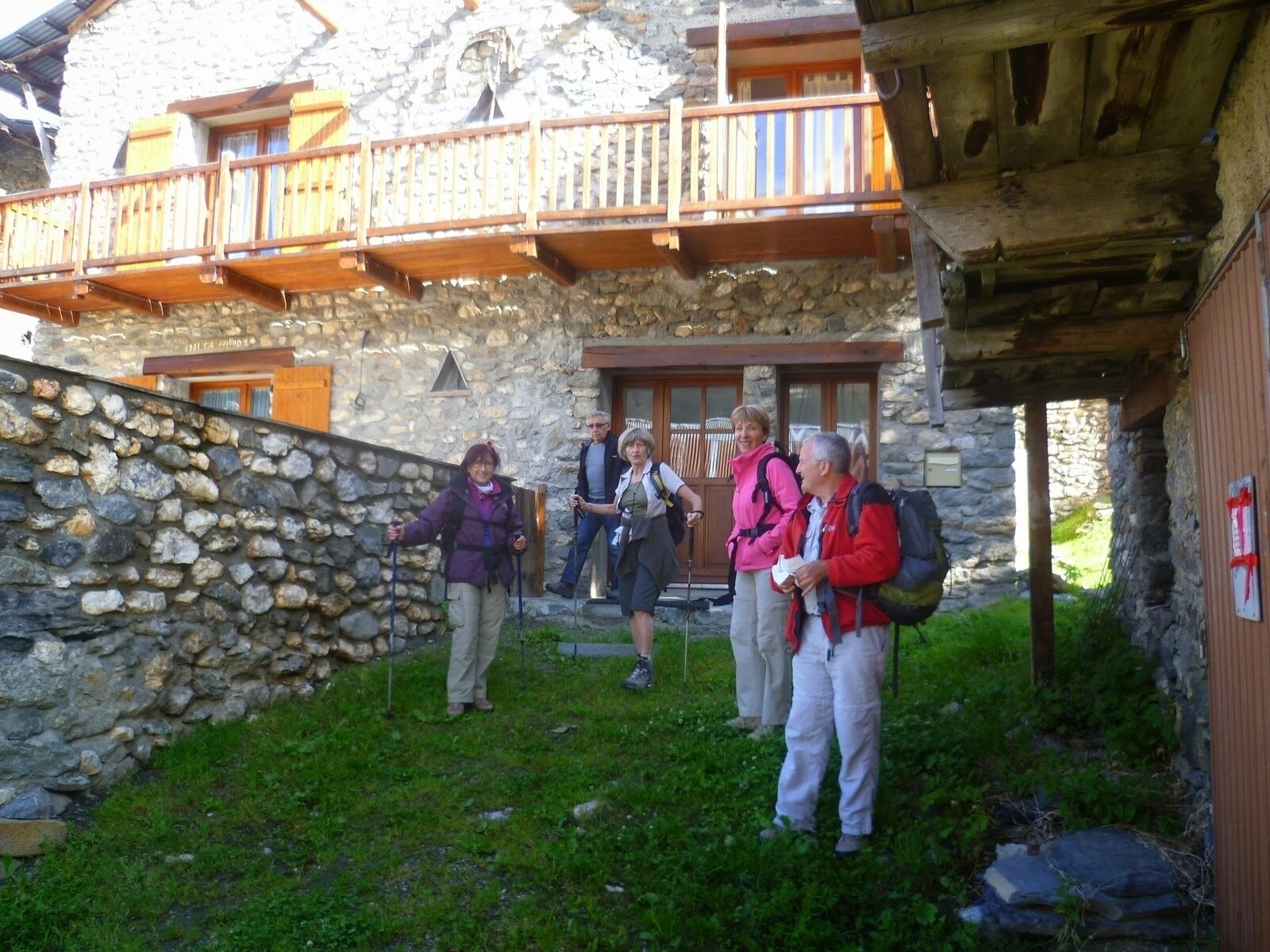 Un edificio de piedra con balcón de madera y pared de piedra.