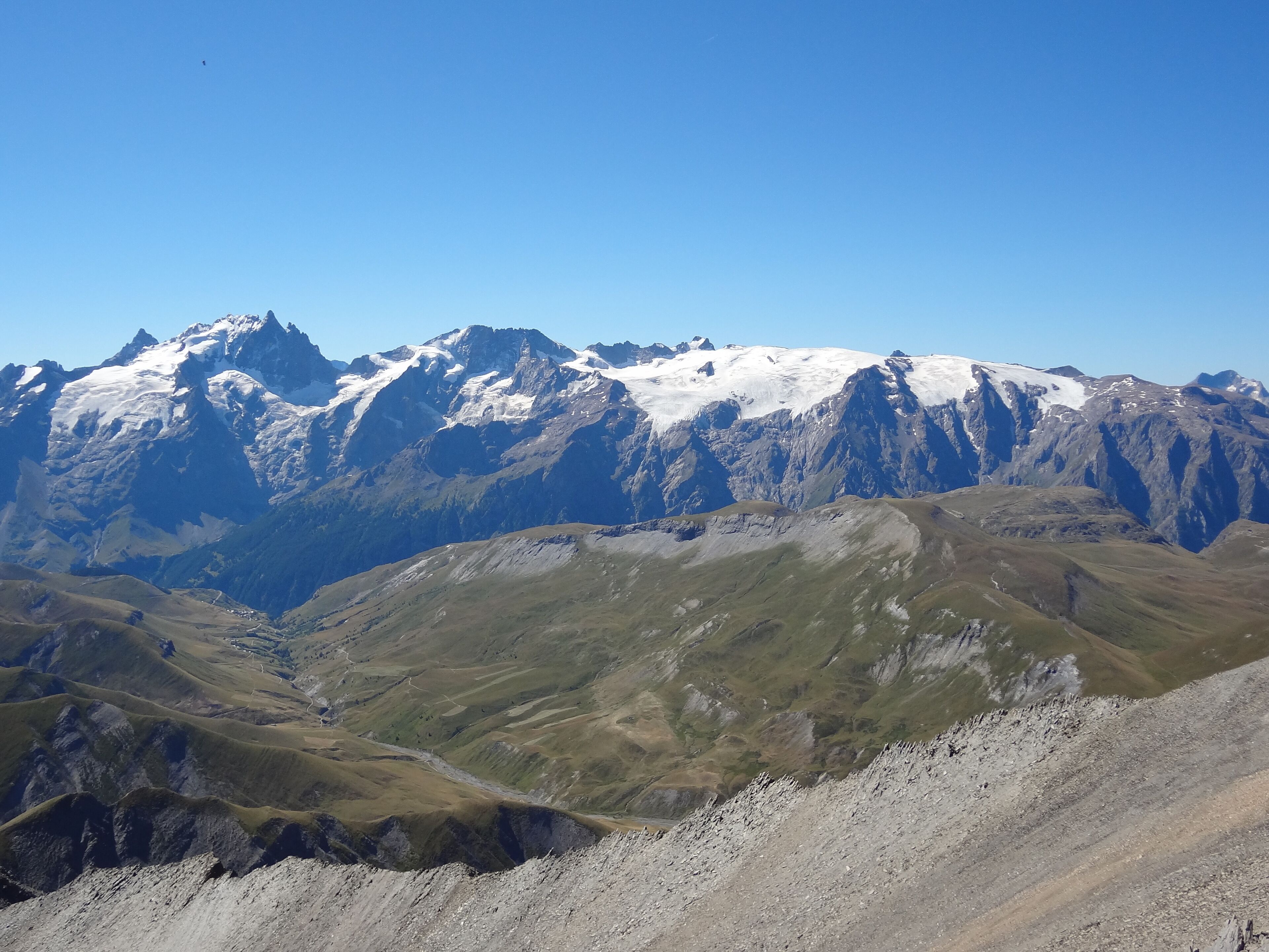 Eine Berglandschaft mit schneebedeckten Gipfeln und einem Tal darunter.