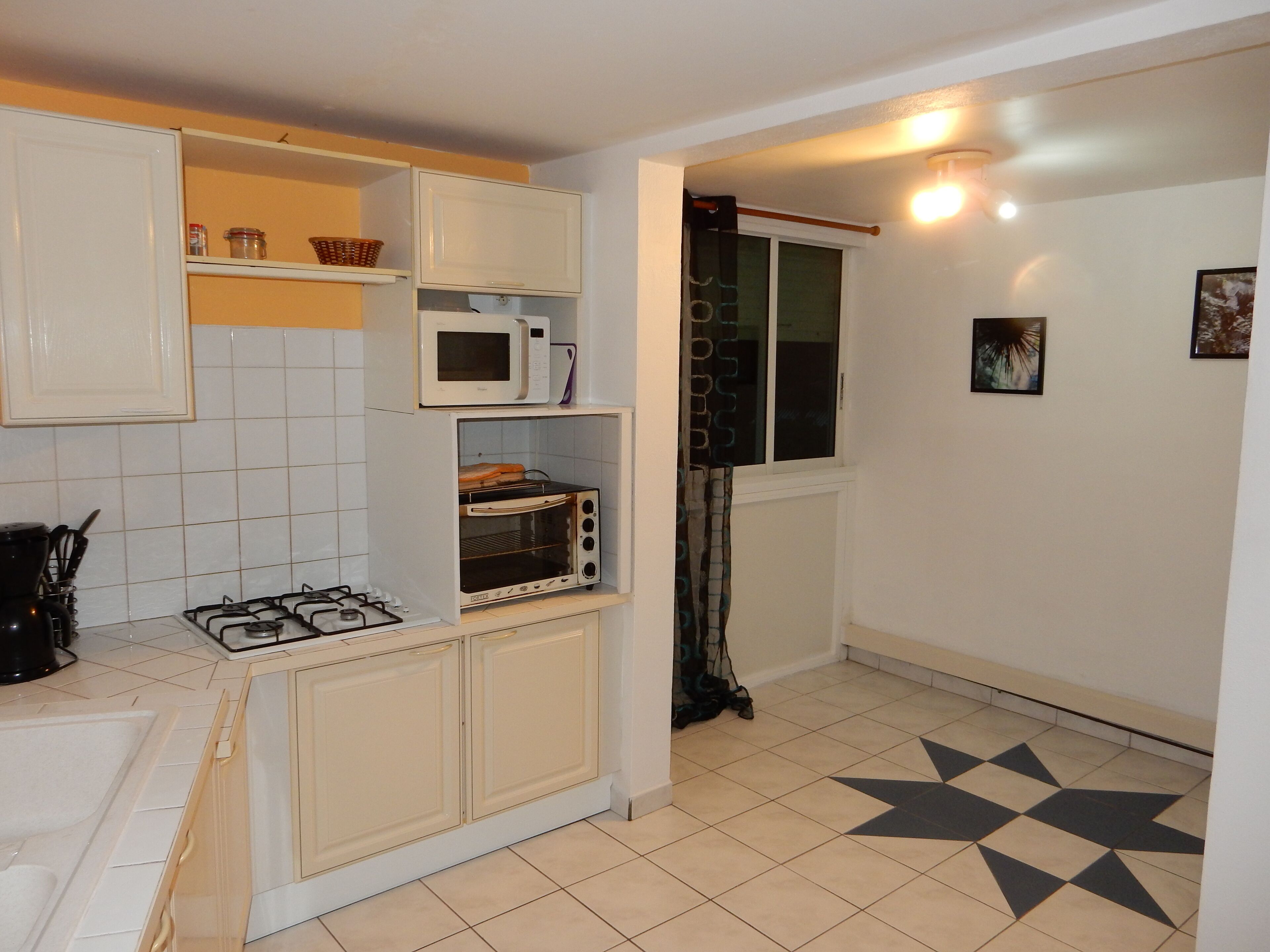 Una cocina compacta con estufa a gas, microondas y horno integrado.