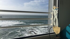 A view from a ship's window with a railing, ocean waves, and a sculpture of a figure. - A studio located in a house directly on the beach in a stunning maritime site (Guilvinec)
