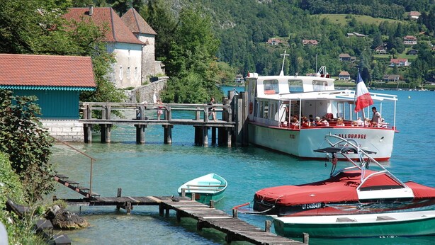 A boat docked at a pier with a small building nearby.
