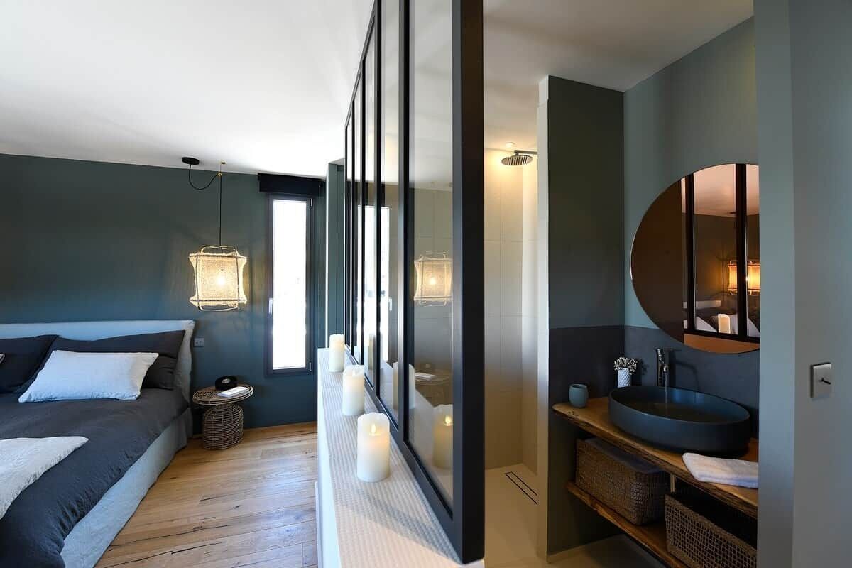 Une chambre à coucher moderne avec un lit, une table de chevet et un grand miroir.