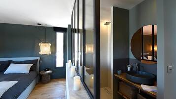 Une chambre à coucher moderne avec un lit, une table de chevet et un grand miroir.