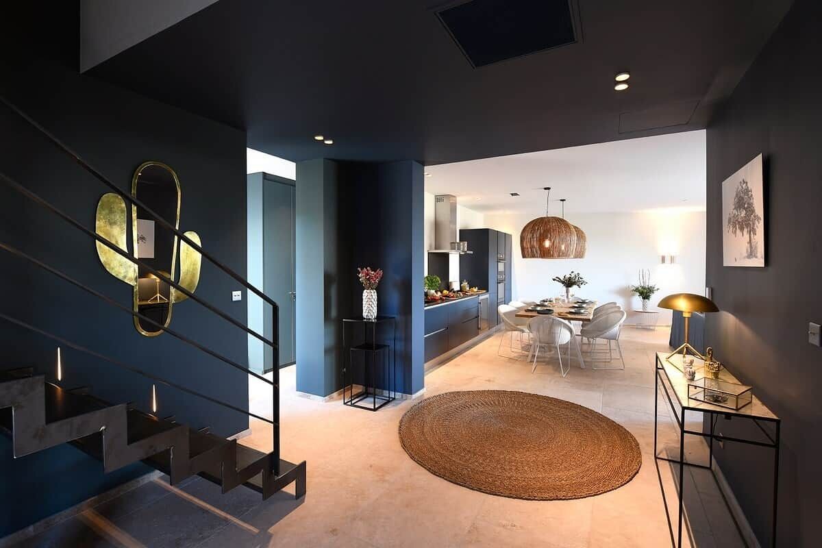 Een modern interieur met een trap, een eetgedeelte en een keuken.