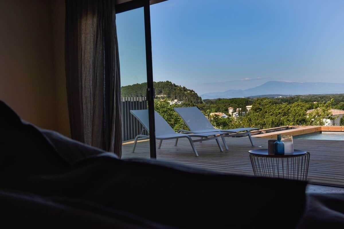 Un balcon avec vue sur une piscine et sur les montagnes.