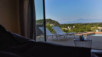 Un balcon avec vue sur une piscine et sur les montagnes.