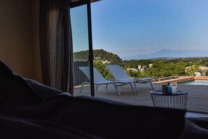 A balcony with a view of a pool and mountains.