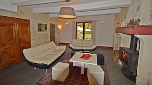 Una sala de estar con sofá, mesa de centro y chimenea.
