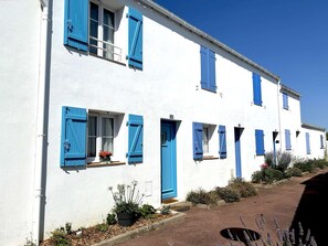 A white building with blue shutters and numbered windows.