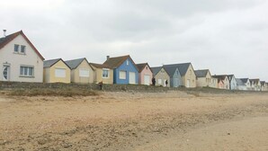 A row of beach houses with a sandy beach in the foreground.