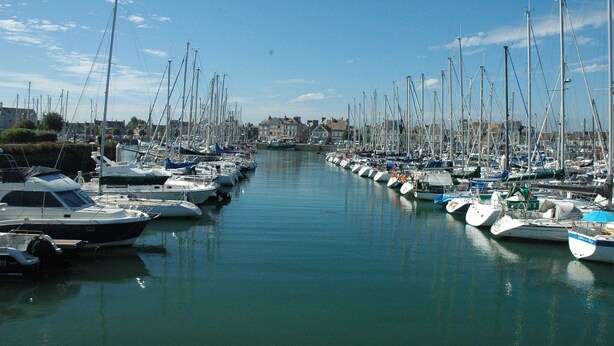 A marina with numerous boats docked along the waterway.