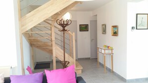 A staircase with a wooden handrail, a small table with colorful balls, and a door in the background.