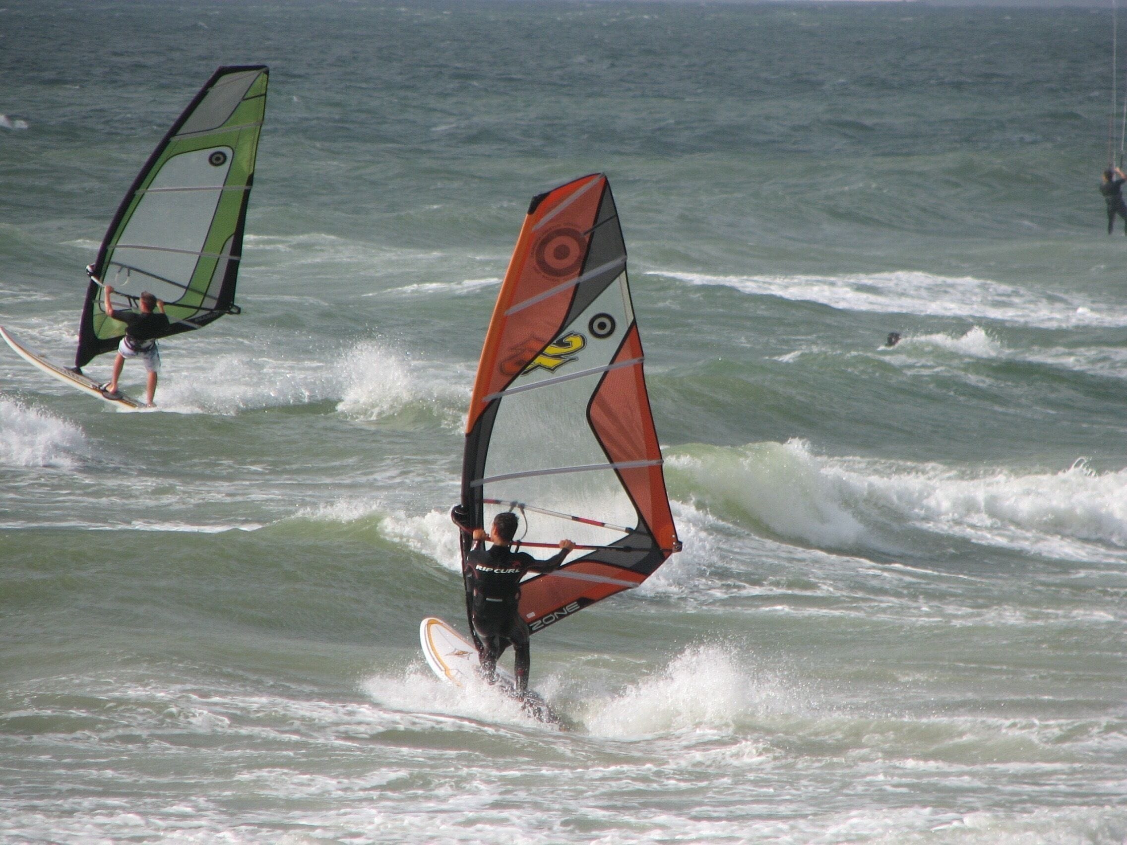 Una persona practicando windsurf sobre el agua.