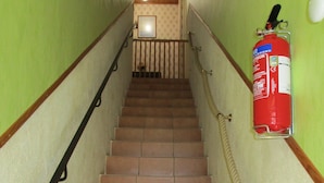 A staircase with a fire extinguisher mounted on the wall, a handrail on the left, and a rope handrail on the right. - independent house in property retaise for 4 people (Le bois plage)