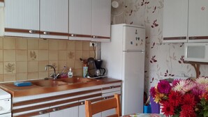 A kitchen with a sink, stove, refrigerator, and microwave. There are cabinets above the sink and a flower vase on the table. - independent house in property retaise for 4 people (Le bois plage)