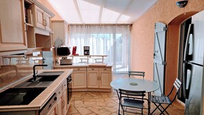 A compact kitchen with a sink, stove, and dining area.