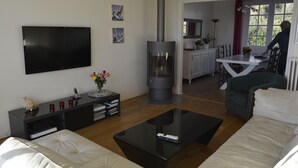Ein modernes Wohnzimmer mit Flachbildfernseher, Kamin, Sofa und Couchtisch.