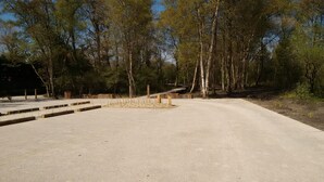 A parking area with a dirt surface and wooden benches. - Sea view at Fort Mahon Plage in the Somme studio 4 people (Fort-Mahon-Plage)