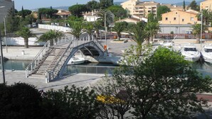 A bridge over a marina with boats, palm trees, and buildings in the background. - Bright 52m2 air-conditioned apartment with Wifi and single-storey closed garage (Fréjus)