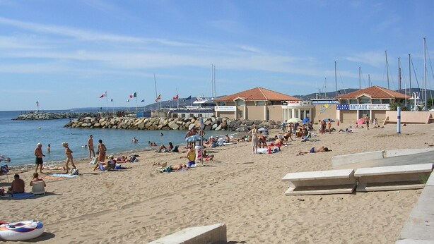 A beach with people sunbathing and swimming, a snack bar, and a marine center. - Bright 52m2 air-conditioned apartment with Wifi and single-storey closed garage (Fréjus)
