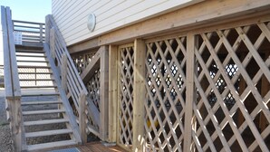 A wooden deck with a metal handrail and a lattice fence. - MAGNIFICENT, COMFORTABLE TRADITIONAL CHALET FACING THE SEA (Gruissan)