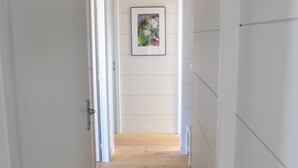 A hallway with wooden flooring, white walls, and a framed picture on the wall. - MAGNIFICENT, COMFORTABLE TRADITIONAL CHALET FACING THE SEA (Gruissan)