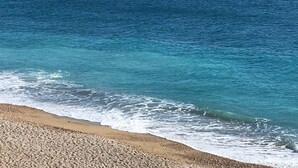 Una playa con agua azul cristalina y una orilla arenosa.