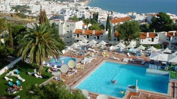 Een resort met een zwembad, ligbedden en parasols.