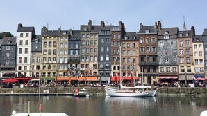 A waterfront with historic buildings and a sailboat docked.